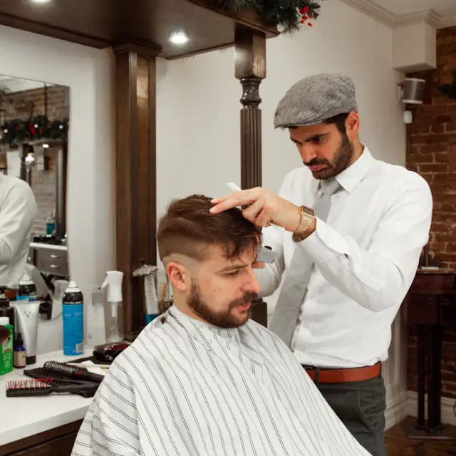 Barber giving a client a haircut in a barbershop